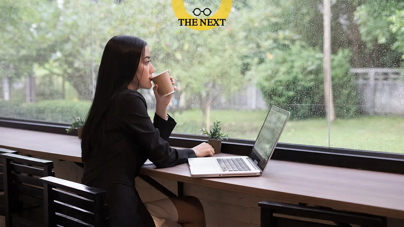 ภาพผู้หญิงจิบหาแฟที่คาเฟ่ อยู่หน้าคอม